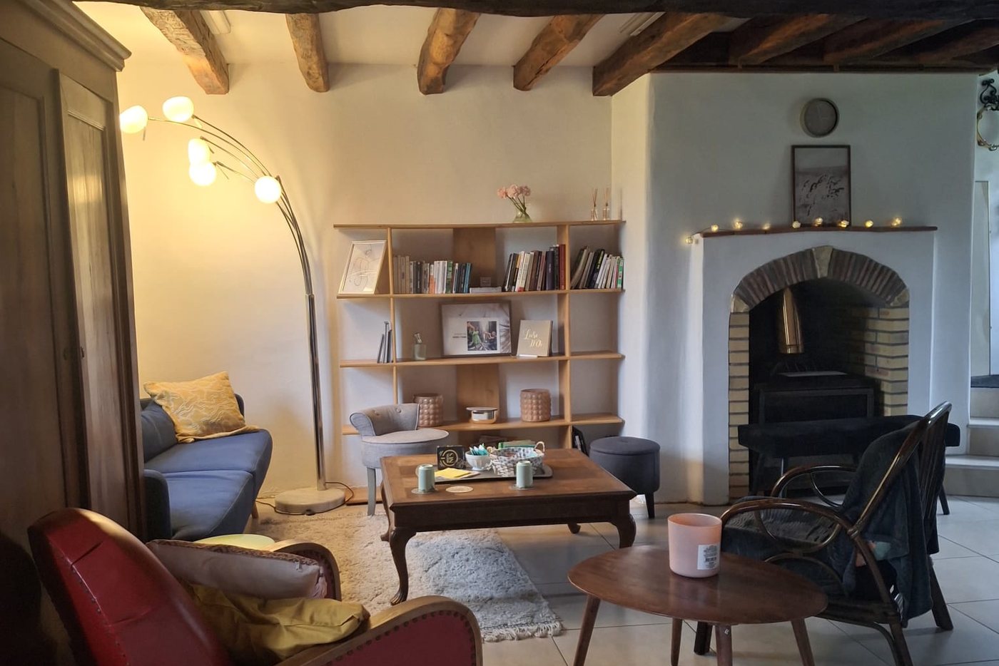 Le salon du gîte L'Ancienne Boulangerie du Grand Verger, avec sa cheminée et sa bibliothèque